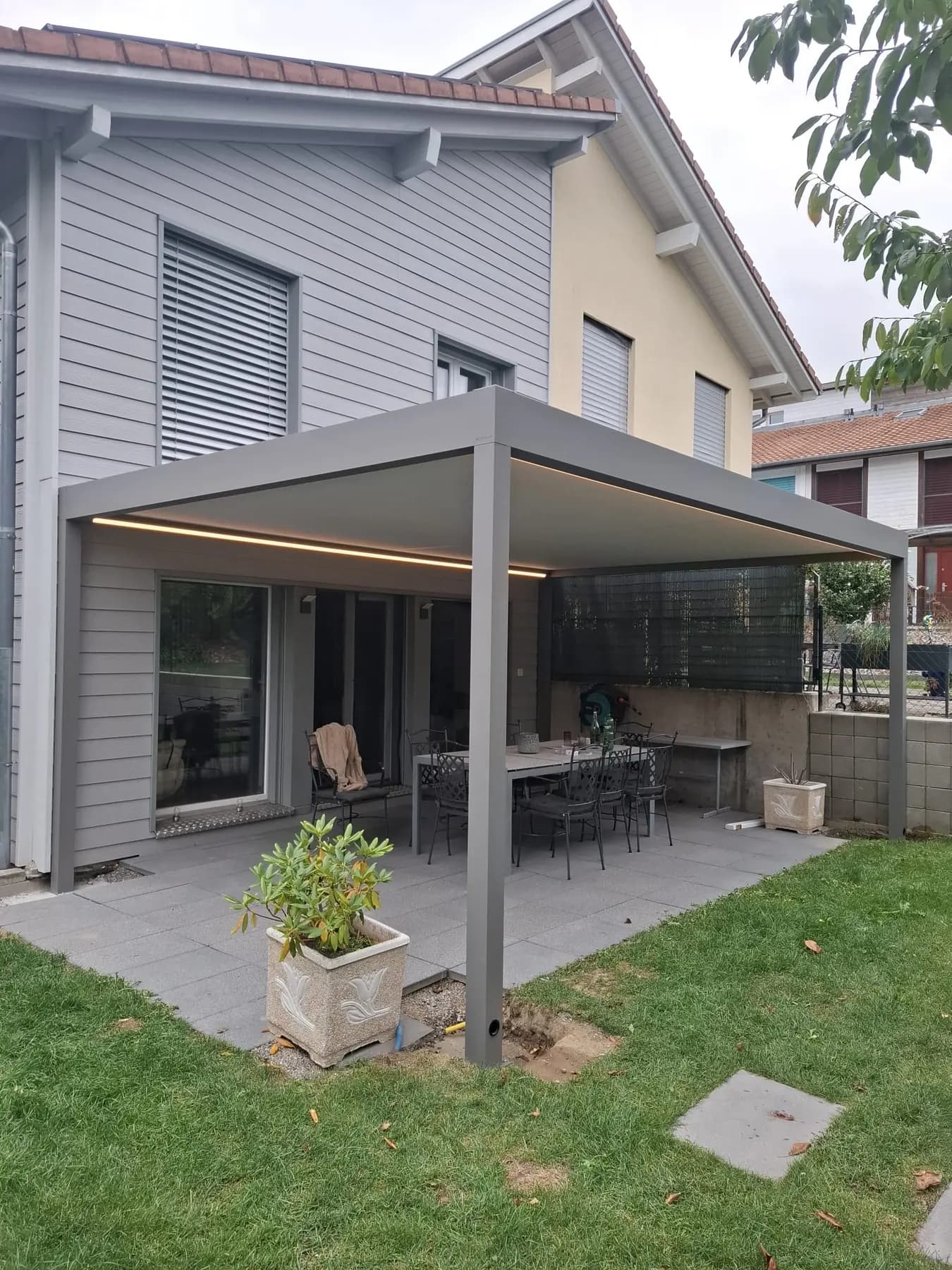 Graue bioklimatische Pergola in Courtaman mit eingeschalteten LED-Leisten