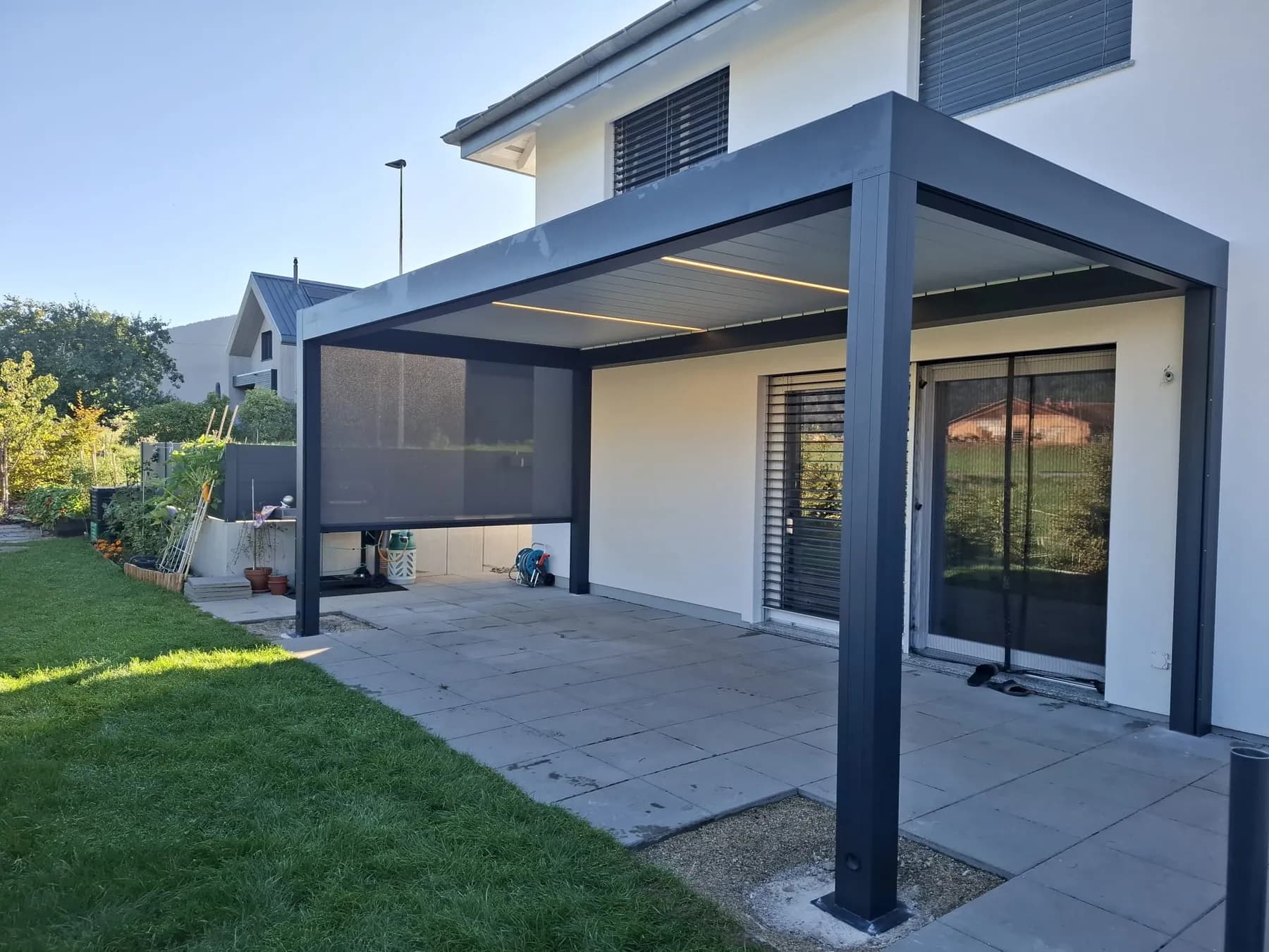 Pergola bioclimatique anthracite à Savagnier avec ses bandeaux LED allumés